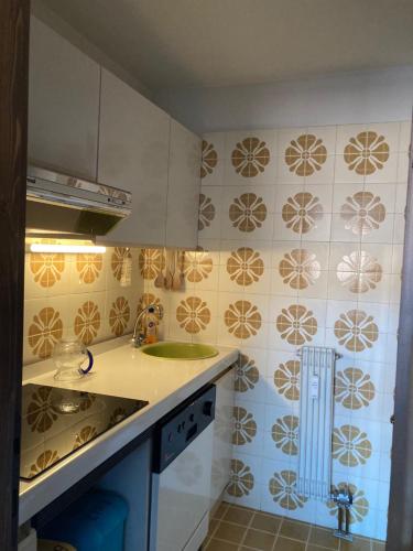 a kitchen with a sink and tiles on the wall at NIGRITELLA in Madonna di Campiglio