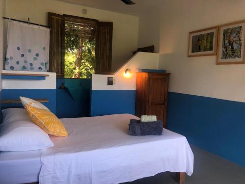 a bedroom with two beds with blue and white walls at Posada Arigalan in Mazunte