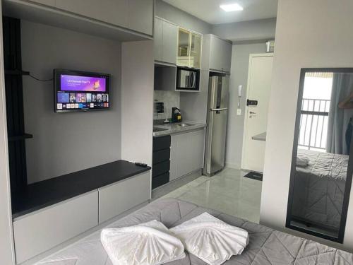 eine Küche mit einem Bett und einem TV an der Wand in der Unterkunft Studio Acolhedor e Moderno no Centro de São Paulo! in São Paulo