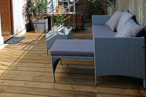 a couch and a table on a patio at Les Tanalis - Chambres d'hôtes & Gîte in Gurs