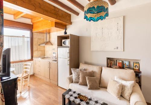 a living room with a couch and a kitchen at Apartamentos Vino Tinto y Restaurante Tomate Rosa in Adahuesca
