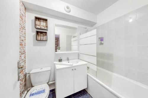 a white bathroom with a sink and a toilet at Magnifique studio la villette avec parking in Aubervilliers