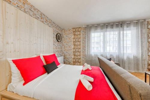 a bedroom with a large bed with red pillows at Magnifique studio la villette avec parking in Aubervilliers