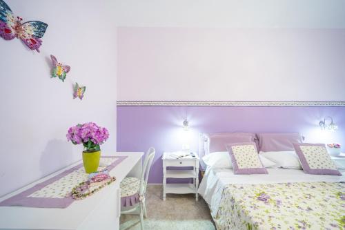 a bedroom with a bed and a table with flowers at Almaré B&B in Crotone