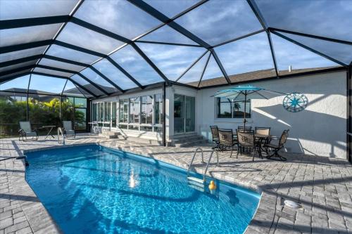 a swimming pool with a glass roof over a patio at 15826 Aqua in Placida