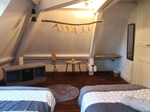 a room with two beds and a tv and a table at Les Tanalis - Chambres d'hôtes & Gîte in Gurs