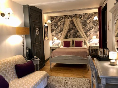 a bedroom with a large bed and a chair at Reglisse et Pain d'Epices - Chambres d'hôtes in Honfleur