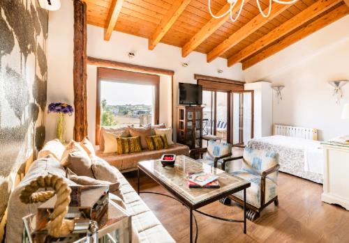 a living room with a couch and a bed at Apartamentos Vino Tinto y Restaurante Tomate Rosa in Adahuesca