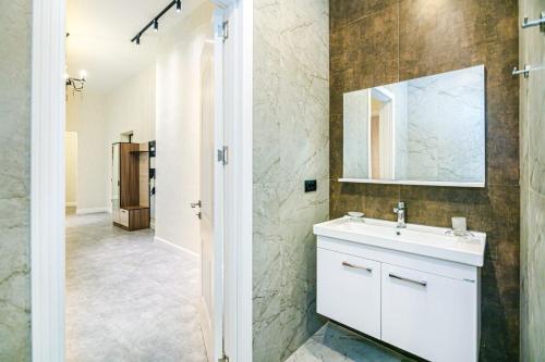 ein Bad mit einem Waschbecken und einem Spiegel in der Unterkunft Comfort City center 2 bedrooms in Baku
