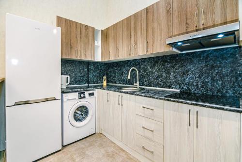eine Küche mit einem weißen Kühlschrank und einem Geschirrspüler in der Unterkunft Comfort City center 2 bedrooms in Baku