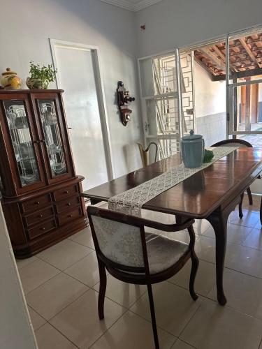 a dining room with a wooden table and chairs at Casa Grande Hospedagem in Brumadinho
