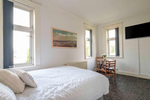 ein weißes Schlafzimmer mit einem Bett und einem Tisch in der Unterkunft Urban Stay: Studio Suite 8 in Parkside