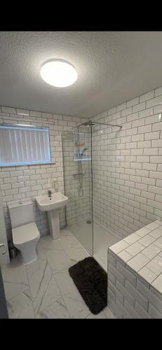 a bathroom with a shower and a toilet and a sink at Entire 3 bedrooom holiday home in Liverpool