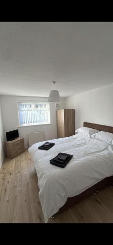 a bedroom with a large white bed with towels on it at Entire 3 bedrooom holiday home in Liverpool