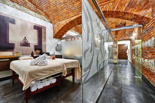 a room with a bed, a table, and a large window at Queen Boutique Hotel in Krakow
