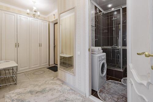 La salle de bains est pourvue d'un lave-linge et d'une douche. dans l'établissement Квартира в ЖК Promenade Expo Block D, à Astana