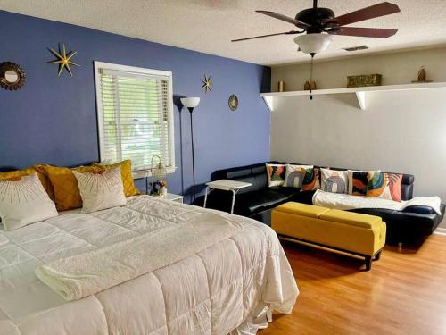 - une chambre avec un grand lit et un canapé dans l'établissement Town & Country-4BR/3BA, 1.5 acres, 20 min FSU/FAMU, à Tallahassee