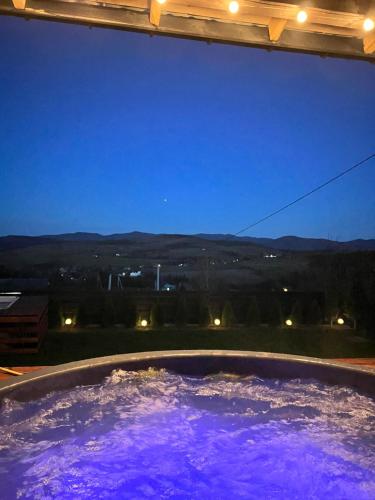 un jacuzzi con agua púrpura por la noche en На Краю Світу, en Murovanka