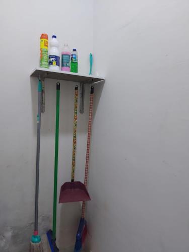 a shelf with two mop in a room at Mini suíte Atitude no centro de Maragogi in Maragogi
