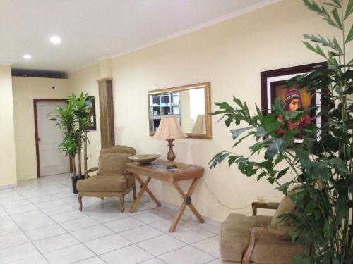 a living room with a table and chairs and a lamp at Hotel Carnaval in La Ceiba