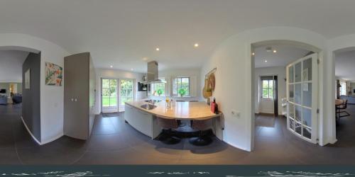 a kitchen with a wooden table in the middle of a room at Onder het dak van Brabant in Mierlo