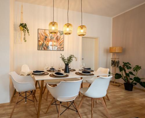 a dining room with a white table and white chairs at maremar - Ideal für Familien - Boxspringbett - Zentral - vollausgestattete Küche - Waschtrockner - Spielecke in Gera