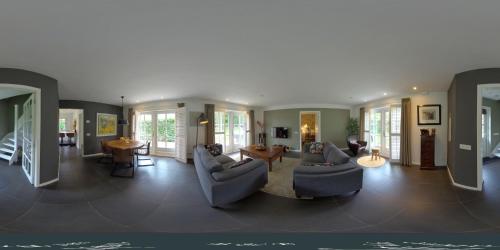 a living room with two couches and a table at Onder het dak van Brabant in Mierlo