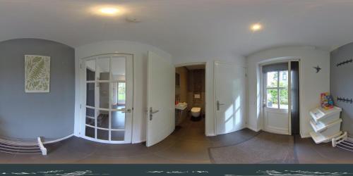 a room with white walls and a hallway with a mirror at Onder het dak van Brabant in Mierlo