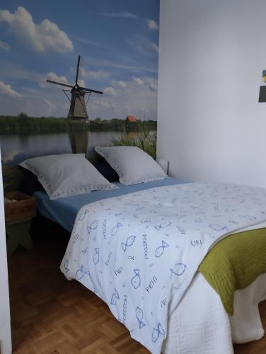 a bedroom with a bed with a windmill in the background at chambres d'hôtes du clos du roi in Pontorson