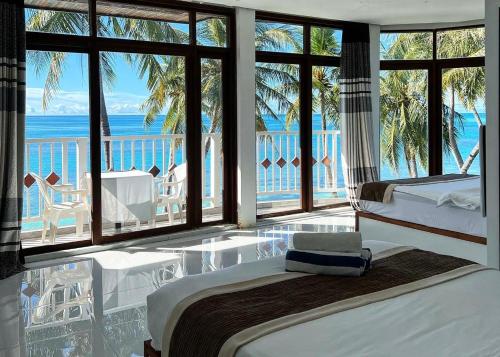 a bedroom with two beds and a view of the ocean at Heron Beach Hotel - The Best Maldivian Getaway in Dhiffushi,Maldives in Dhiffushi