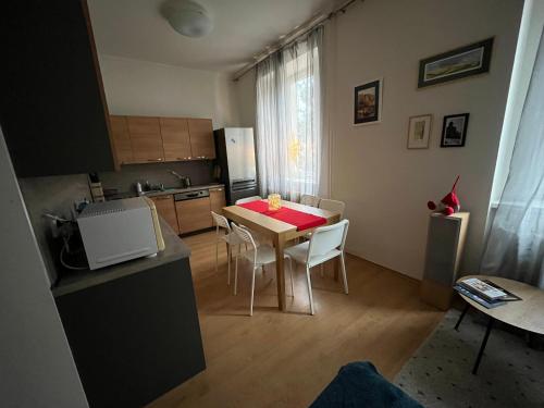 - une cuisine avec une table et des chaises dans la chambre dans l'établissement Apartmán Raisova 1180, à Karlovy Vary