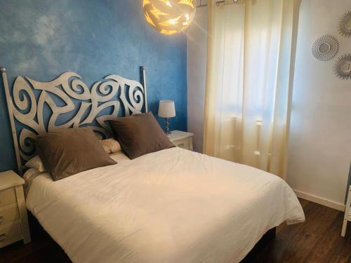 a bedroom with a white bed with a large headboard at Viernes Home in Torrox Costa