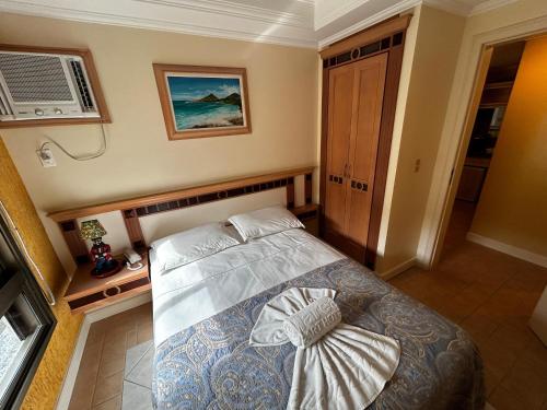 um quarto com uma cama e ar condicionado em Golfinhos ApartHotel a beira-mar!! em Florianópolis