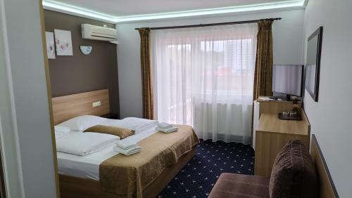 a hotel room with a bed and a window at Vila Cristal in Baile Felix