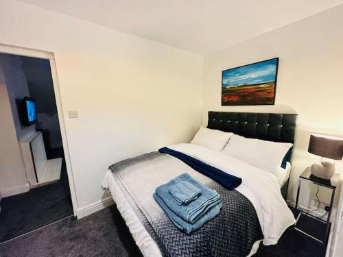 um quarto com uma cama com uma toalha azul em 1 Luxe Exec Bedroom Apt Derby em Derby