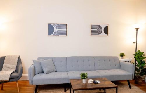 a living room with a blue couch and a table at Superb 1BR Apartment in NYC! in New York