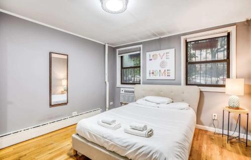 a bedroom with a large bed and two windows at Superb 1BR Apartment in NYC! in New York