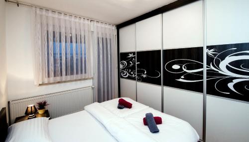 1 Schlafzimmer mit 2 weißen Betten und roten Kissen in der Unterkunft City Osijek, CENTAR, SELF CHECK IN in Osijek