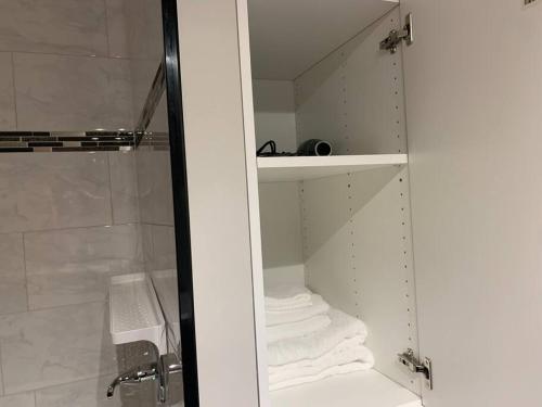 a bathroom with a walk in shower with towels at Sleek 3 bedroom home close to Exchange W parking in Winnipeg