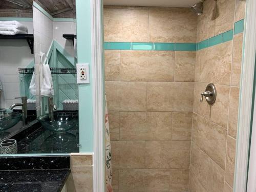 La salle de bains est pourvue d'une douche avec une porte en verre. dans l'établissement Seaside Cottage, à Clearwater Beach