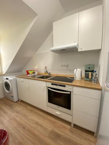 a kitchen with white cabinets and a stove top oven at Annie´s Appartements in Mannheim