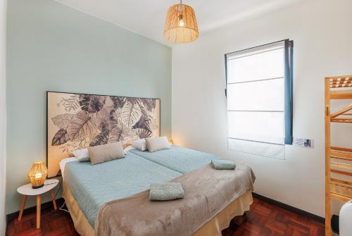 Un dormitorio con una cama grande y una ventana. en Quintinha Tropical - Panoramic Gateway to Madeira, en Funchal