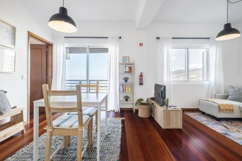 a living room with a table and a bedroom at Casa da Angela - By WeHost in Funchal