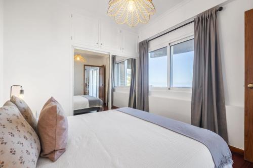 um quarto com uma cama com uma janela e um lustre em Casa da Angela no Funchal