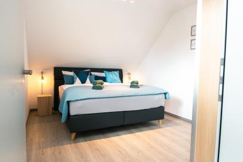 a bedroom with a large bed with blue pillows at Luxuswohnung am Steinhuder Meer - Tierfreundlich - D in Wunstorf
