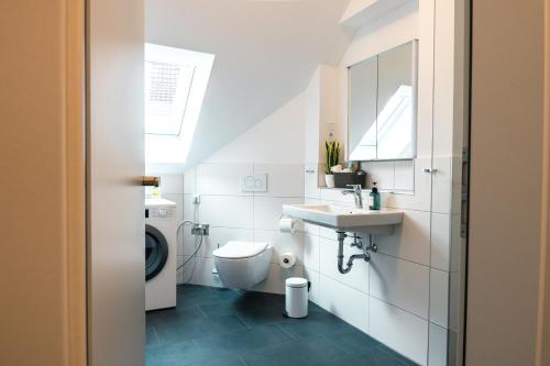 a white bathroom with a sink and a toilet at Luxuswohnung am Steinhuder Meer - Tierfreundlich - D in Wunstorf