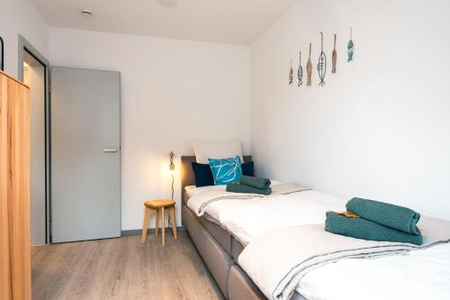 two beds in a room with white walls and wooden floors at Luxuswohnung am Steinhuder Meer - Tierfreundlich - D in Wunstorf
