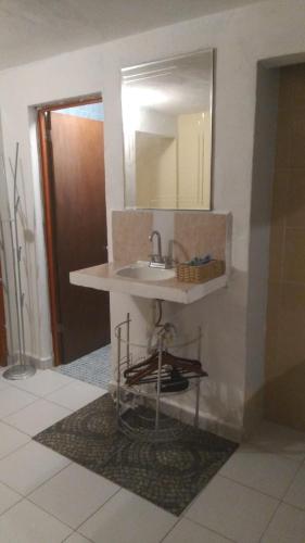 a bathroom with a sink and a mirror on the wall at Corazón Abierto in Chicxulub