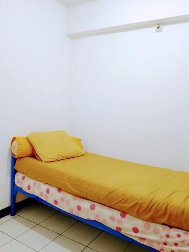 1 cama con manta amarilla y lunares en Indah property en Cibubur