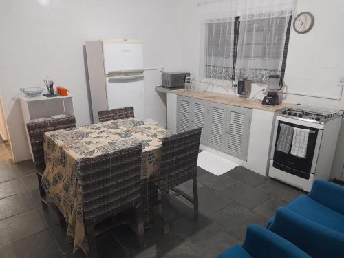 a kitchen with a table and a kitchen with a stove at Suíte com uma cama de casal e uma cama de solteiro in Itu